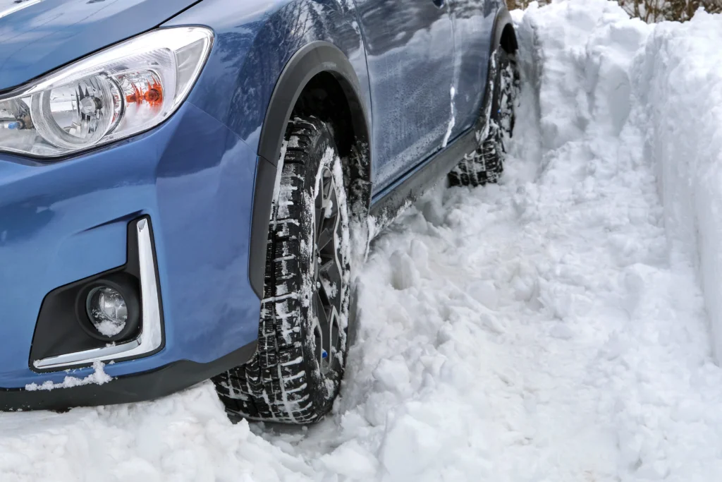 blue car stuck in deep snow