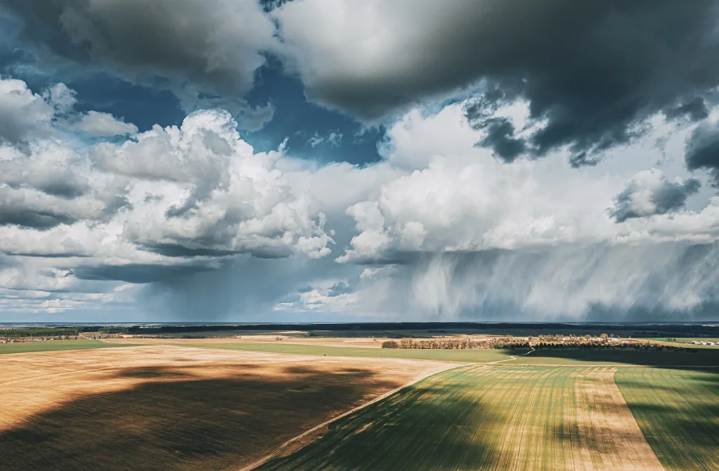 arial shot of a field with dramatic fluffy clouds rolling over