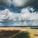 arial shot of a field with dramatic fluffy clouds rolling over